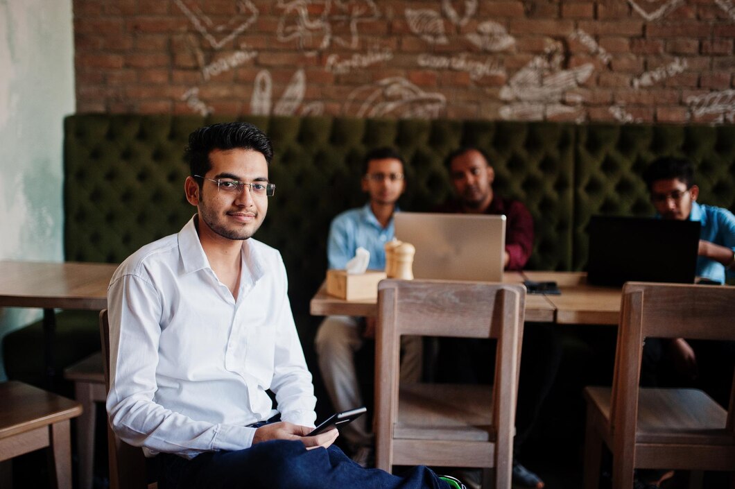 group-four-south-asian-men-s-posed-business-meeting-cafe-indians-work-with-laptops-together-using-various-gadgets-having-conversation-indian-man-with-mobile-phone_627829-5227